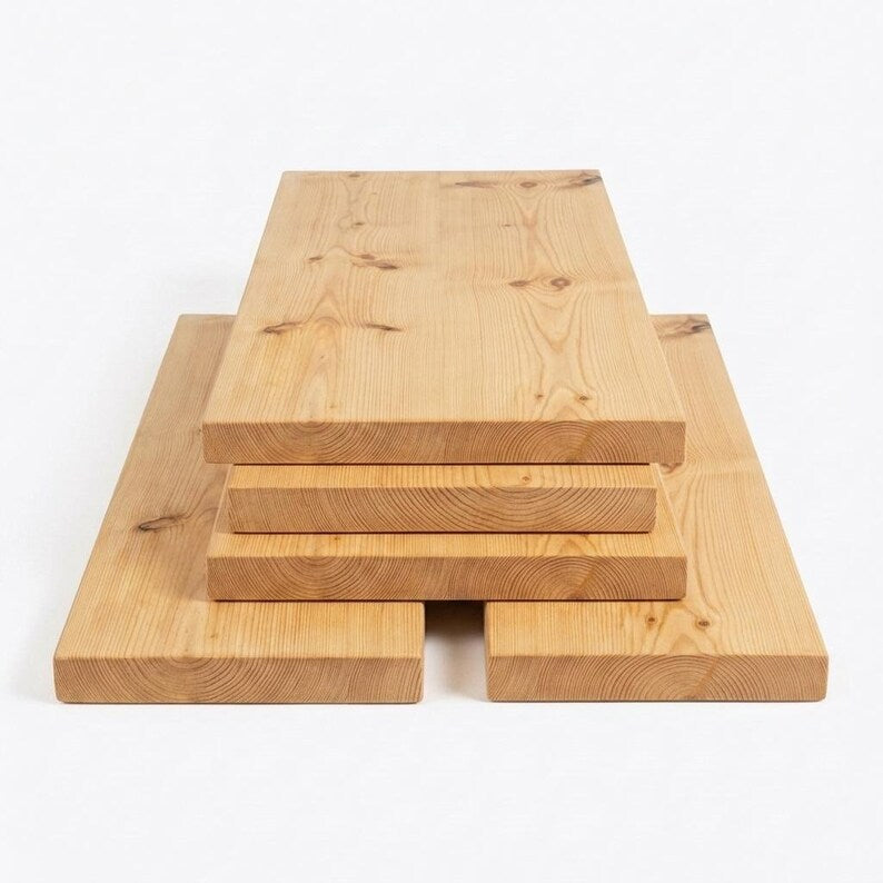 Stack of four light brown wooden boards with two longer boards underneath as a base