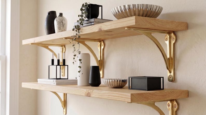 Two natural wood shelves with polished brass brackets