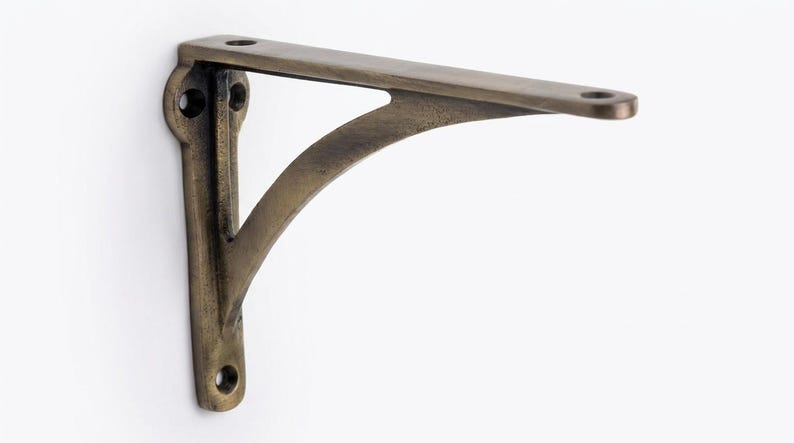 Antique brass shelf bracket with vertical mounting plate and curved brace